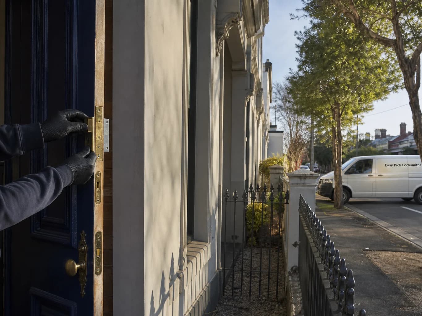 A locksmith working on a front door in Armadale VIC 3143, the Easy Pick Locksmiths van at the kerb